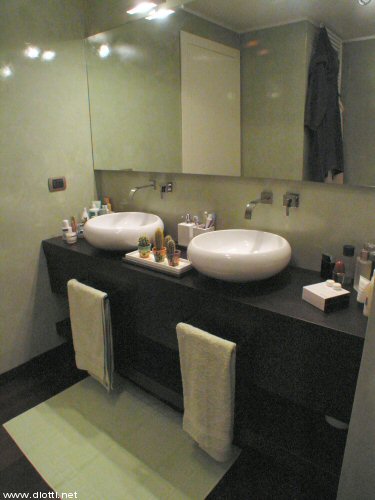 Ecco il bagno padronale del primo piano, quello che serve le due camere, matrimoniale e cameretta. Molto belli i due lavabi in appoggio con relativi miscelatori che mostrano un perfetto coordinamento fra il progetto dell'abitazione e la produzione dell'arredamento: qui una vista d'insieme.